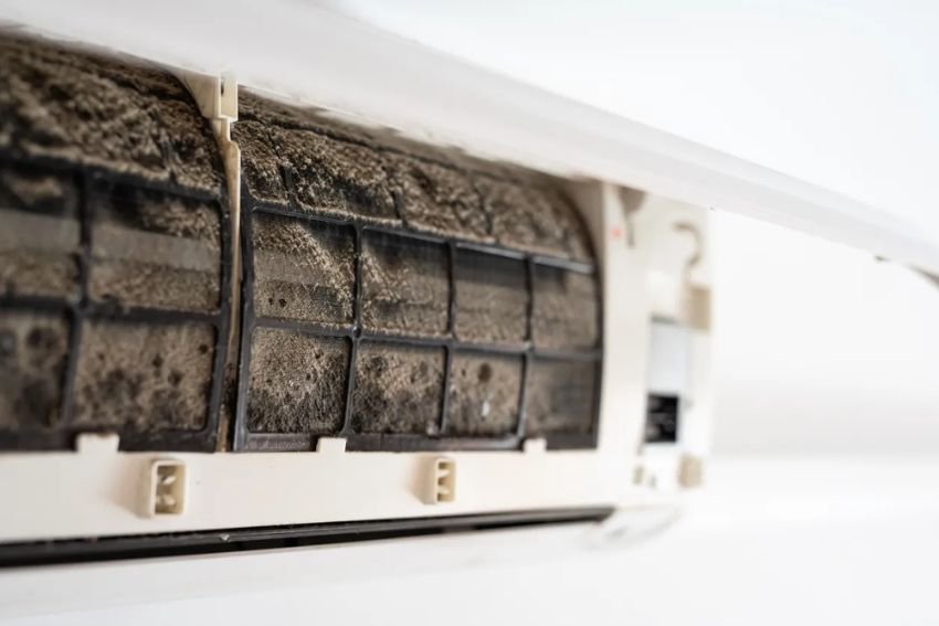 Detailed view of a dirty air conditioner, emphasizing dust buildup, relevant for HVAC mold removal services in Chicago, IL.